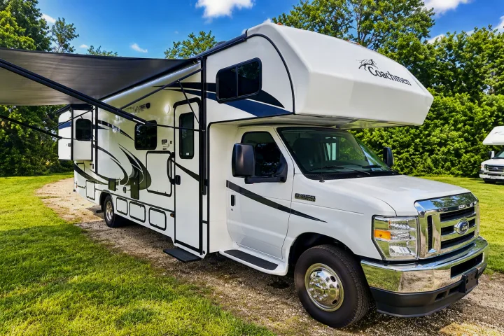White Coachmen RV rental with extended awning parked on a sunny day, gravel drive, ready for adventure.. Forester Classic 2021