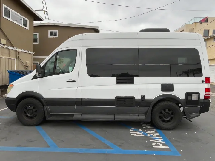 White camper van, perfect for rv rental adventures, featuring tinted windows, black wheels, and RV conversion details.. Roadtrek Roadtrek Class B 2007