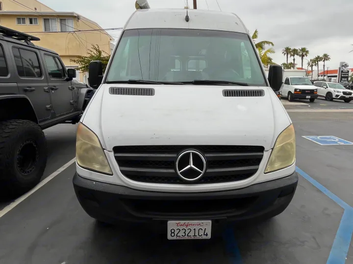 Front view of a white Mercedes Sprinter van, likely an rv rental, parked next to a gray Jeep. California plate 82321C4.. Roadtrek Roadtrek Class B 2007