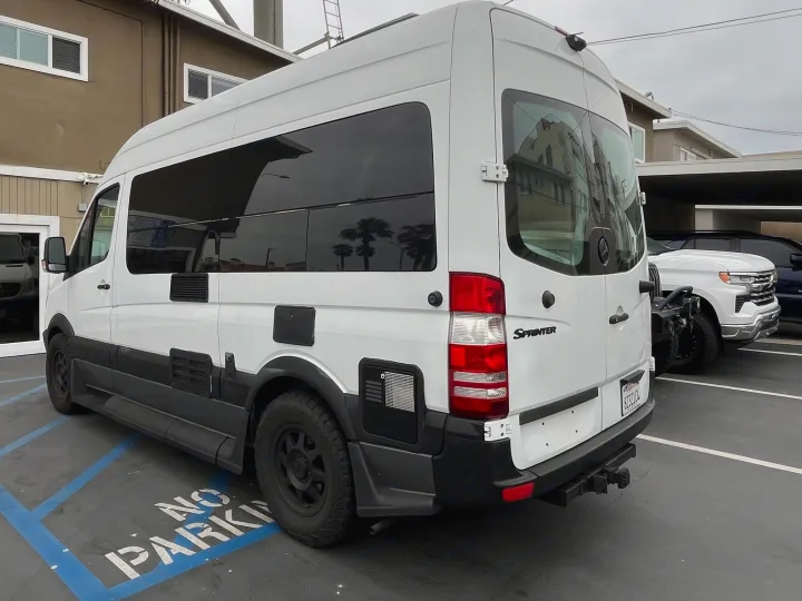 White Mercedes Sprinter RV rental with tinted windows & black trim, parked in a no-parking zone.. Roadtrek Roadtrek Class B 2007