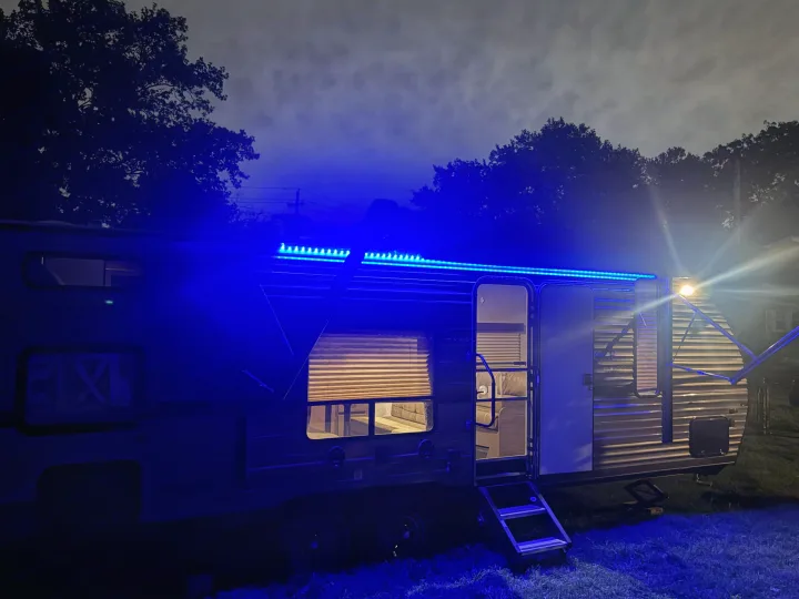 This RV rental shines at night with vibrant blue LED lights, inviting you inside for a cozy camping experience.. Forest River Cherokee Grey Wolf 2018
