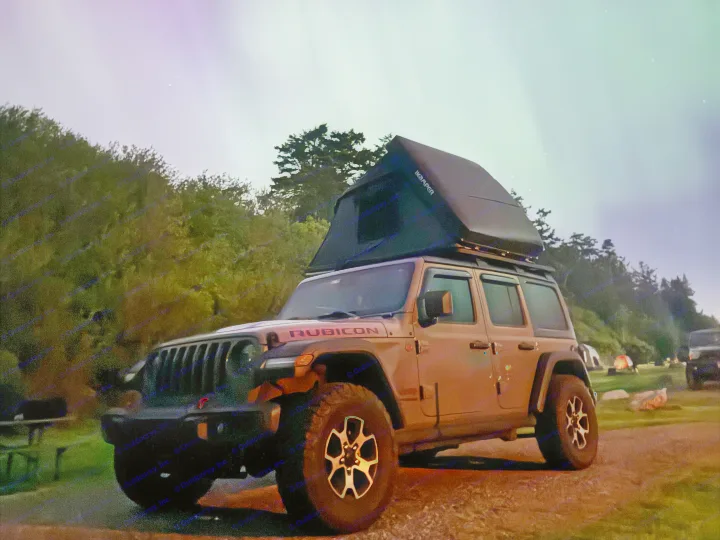 RV rental adventure: a Jeep Wrangler with a rooftop tent camped under the stunning Northern Lights, perfect for aurora camping!. Jeep Wrangler Rubicon Unlimited 2021