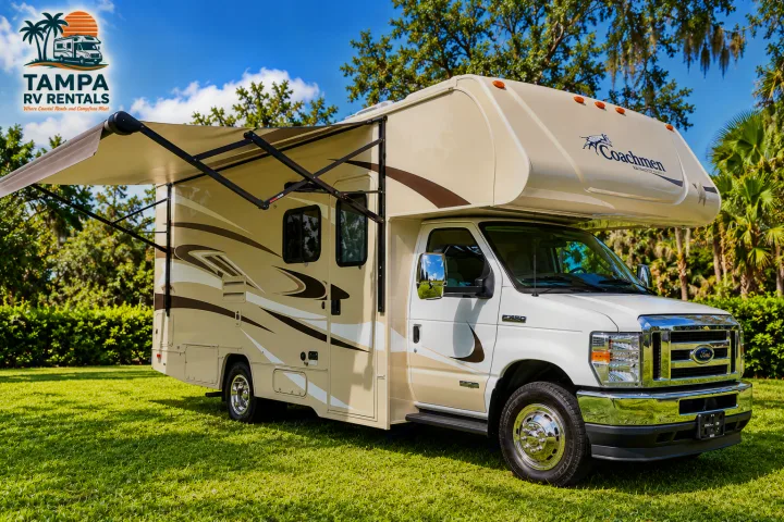 Spacious cream Coachmen RV rental with an extended awning, parked on green grass under a sunny sky. Ideal for your next RV adventure.. Winnebago Minnie Winnie 2024