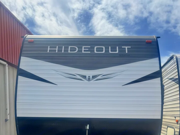 Front view of a sleek Hideout by Keystone travel trailer, perfect for an RV rental. Features black, white, and gray design.. Keystone RV Hideout LHS 2019
