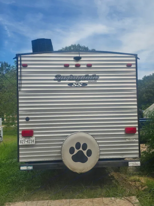 Rear view of an rv rental: a Keystone Springdale travel trailer with a paw print spare tire cover and Texas plate.. Keystone RV Springdale SSR 2018