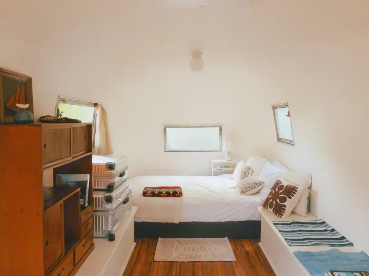 Stylish RV rental bedroom interior with a comfy bed, wood floors, and warm decor, ideal for travel.. Airstream Land Yacht 1960