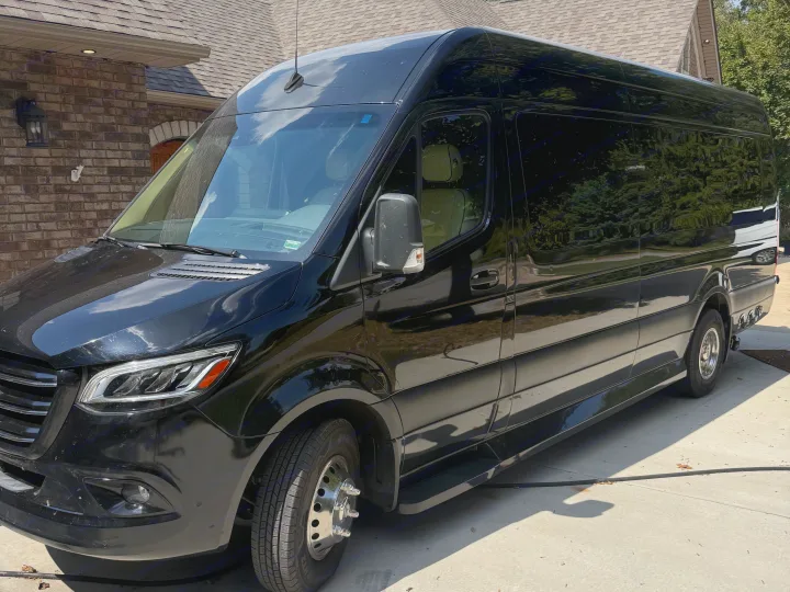 This sleek black luxury RV rental van is seen parked, showcasing its modern design.. Midwest Automotive Designs Luxe Cruiser 2021