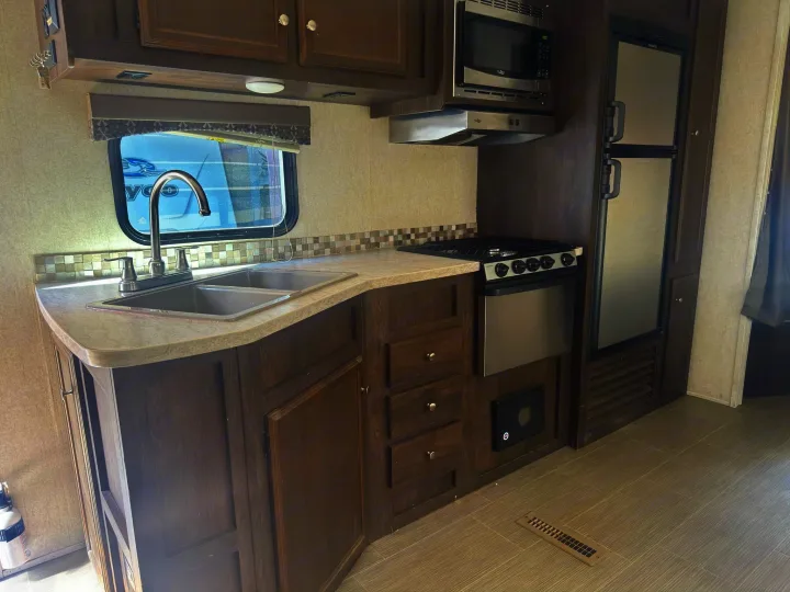 This RV rental offers a compact kitchen with a sink, stove, microwave, fridge, and dark wood cabinets for all your needs.. Starcraft GPS 2018