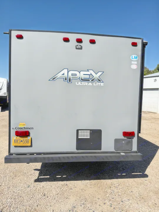 Rear view of a grey Apex Ultra Lite travel trailer by Coachmen with Alaska plate KKS 598. Ideal for your next rv rental journey, showing rear lights & camera.. Coachmen Apex 2020
