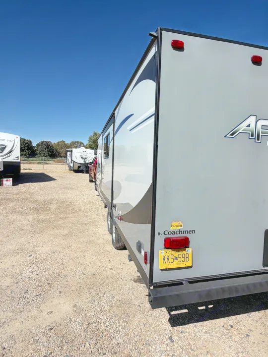 Grey Coachmen travel trailer with an Alaska plate (KKS 598) on a gravel lot, ready for rv rental. Other RVs are visible.. Coachmen Apex 2020