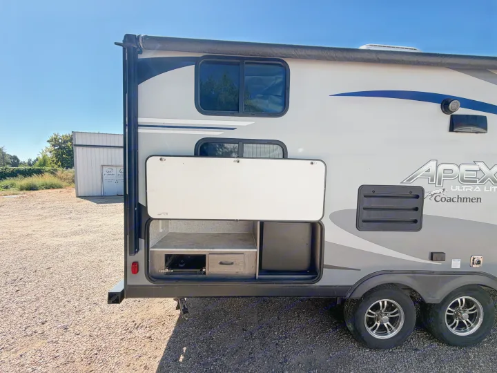 Side view of an Apex Ultra Lite Coachmen RV rental, featuring an open outdoor kitchen with storage, perfect for camping trips.. Coachmen Apex 2020