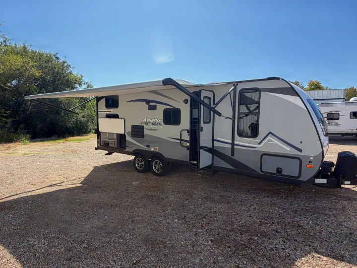 This Apex Ultra Lite Coachmen travel trailer, ideal for RV rental, features an outdoor kitchen and extended awning.. Coachmen Apex 2020
