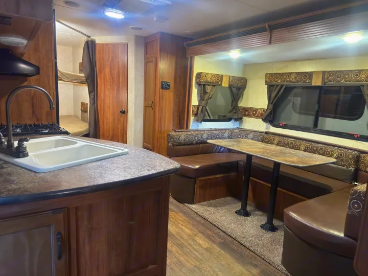 Spacious rv rental interior with kitchen, U-shaped dinette, and cozy bunk beds for comfortable travel.. KZ C250BHS 2015