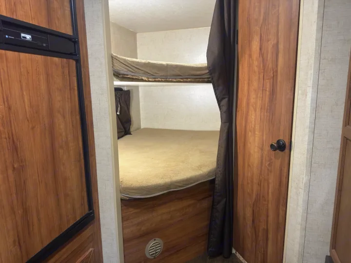 RV rental: Compact interior featuring bunk beds, a Norcold refrigerator, and wood-paneled walls for a cozy stay.. KZ C250BHS 2015