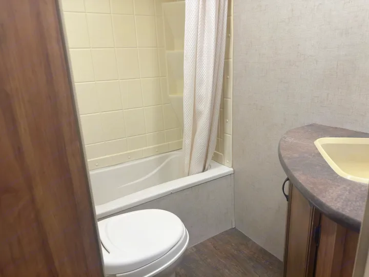 Clean, compact RV rental bathroom featuring a shower, toilet, and vanity sink for comfortable travel.. KZ C250BHS 2015