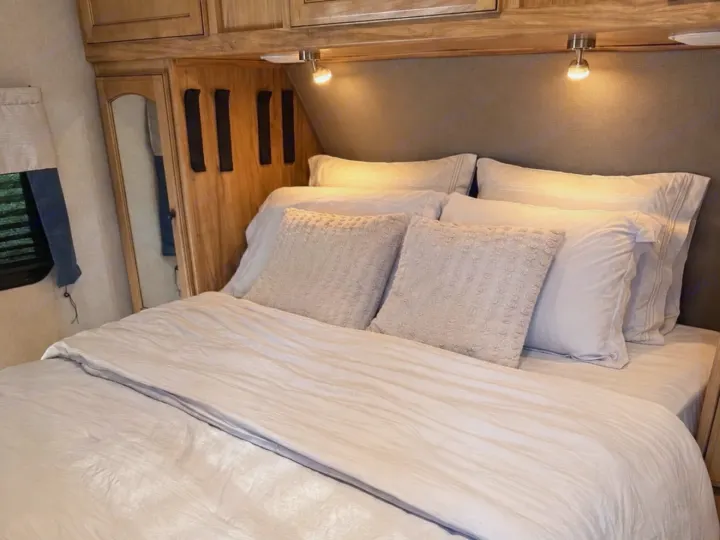 Cozy RV rental bedroom features light bedding, plush pillows, and adjustable reading lights for a comfortable interior.. Coachmen Coachmen Freedom Express Ultra Lite 292BHDS 2019