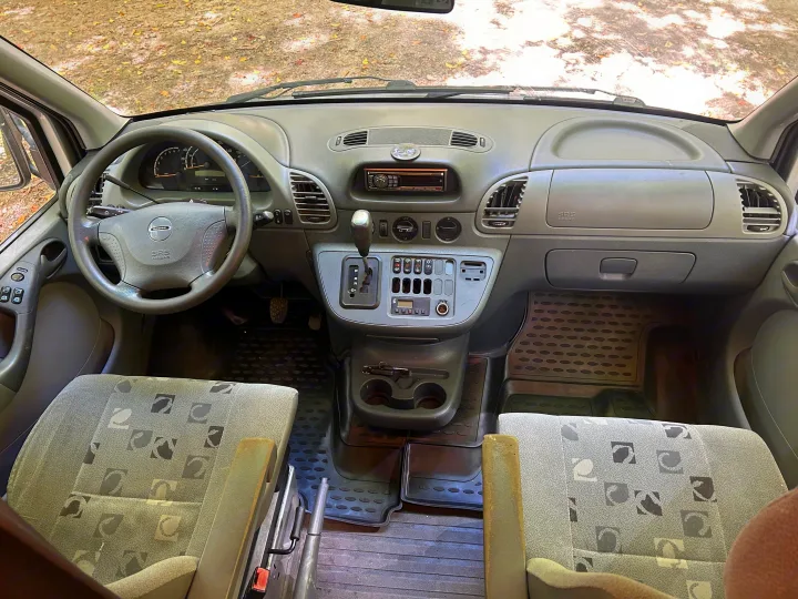 Dodge Sprinter RV rental interior featuring a gray dashboard, steering wheel, automatic shifter, and patterned seats.. Dodge Sprinter 2005