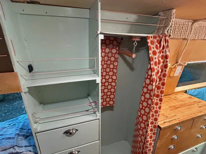 RV rental interior: Custom green cabinets, shelving, and a polka-dot curtained wardrobe offer smart storage.. Dodge Sprinter 2005