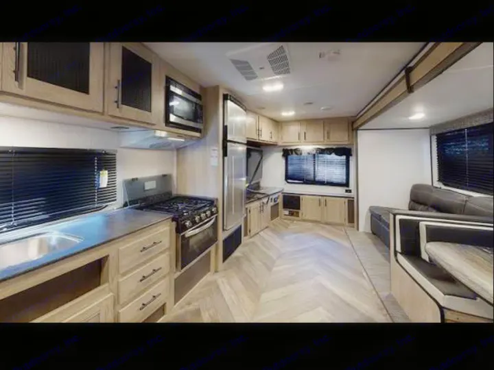 Explore this RV rental's modern interior. Features a well-equipped kitchen, dining booth, and comfortable living space.. Heartland RVs Prowler 2022