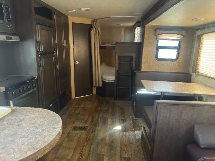 Spacious RV rental interior showing a modern kitchen, comfortable dinette, and bunk beds, ideal for family travel.. Forest River 270BHS 2016