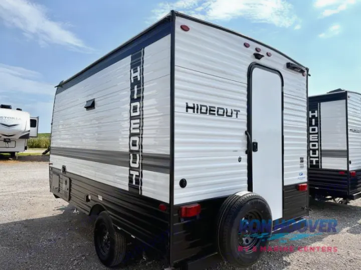 Ready for your next trip: a white and black Hideout travel trailer RV rental, seen parked outdoors with a spare tire.. Hideout Sport 140RE 2025