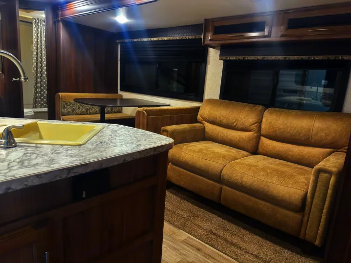 Modern RV rental interior: A kitchen counter, dining booth, and comfy sofa furnish this cozy travel trailer.. Jayco Jay Feather 2018