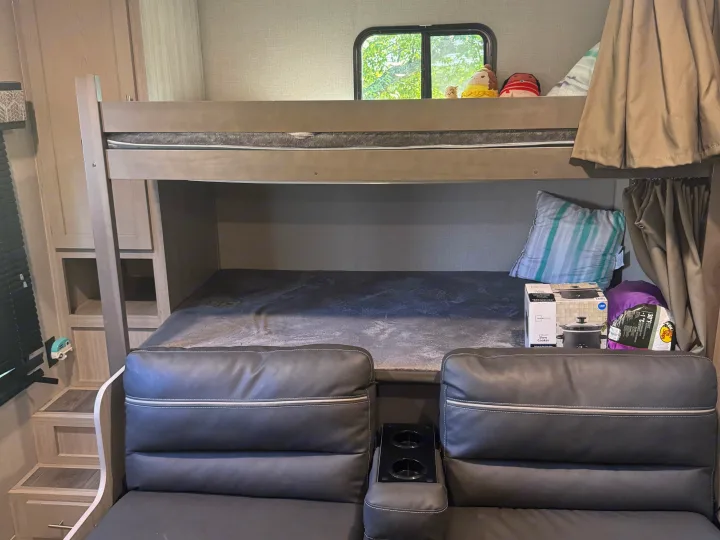 RV rental interior features bunk beds, built-in steps, and seating with cup holders, perfect for family trips.. Coachmen Catalina summit series 8 2023