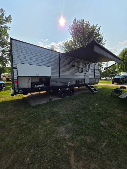 RV rental at a sunny campsite with extended awning and outdoor kitchen. Ready for outdoor adventure and relaxation.. Forest River Catalina 2024