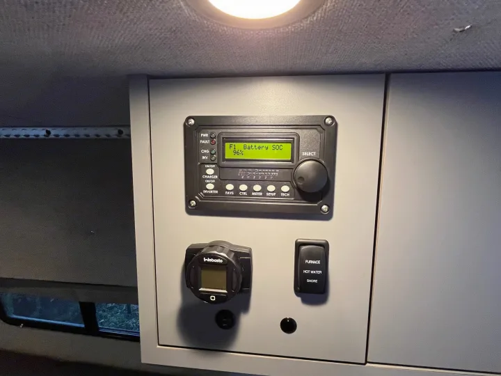 RV rental interior: Power management panel (96% battery SOC), Webasto heater control, and switches for furnace, hot water, shore power.. Mercedes Benz Sprinter 144 High Roof 4WD 2020