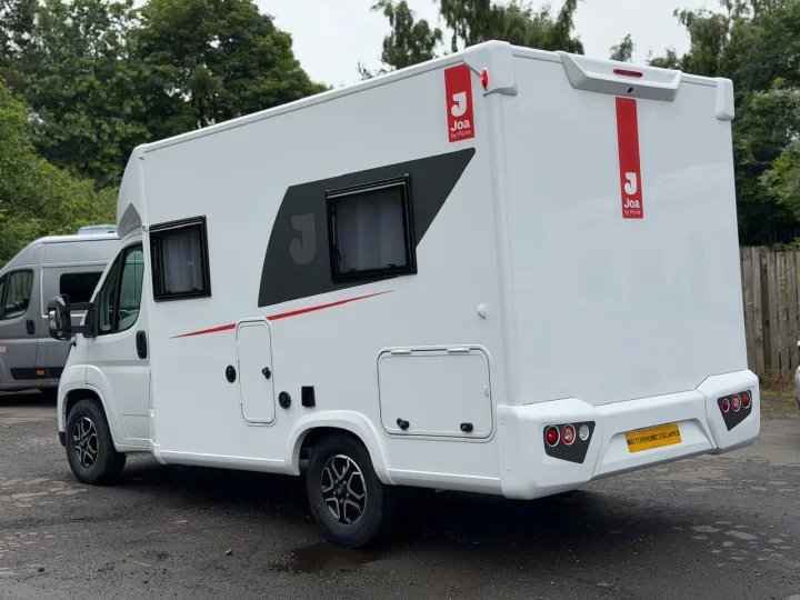 White Joa motorhome RV rental, ready for travel. Features black windows & red accents. Great for campervan adventures.. JOA 60F 2027