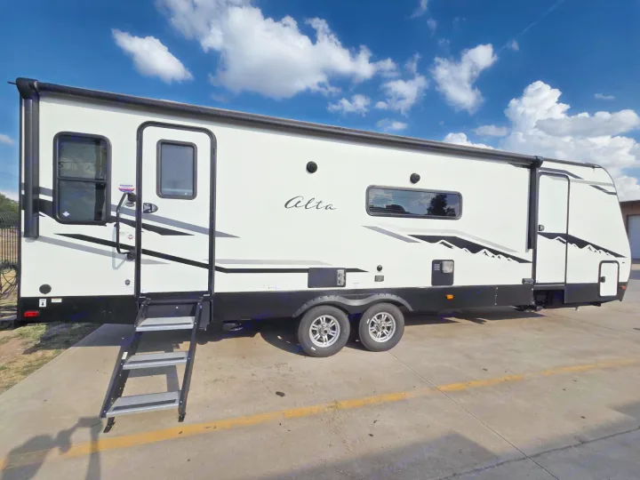 White Alta travel trailer with steps extended, ready for an RV rental adventure under a clear sky.. Alta 2850KRL 2021