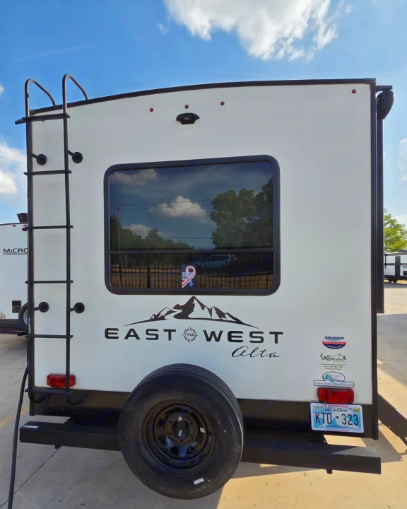 Rear view of an East West Alta RV rental, showing the ladder, spare tire, and Oklahoma license plate.. Alta 2850KRL 2021
