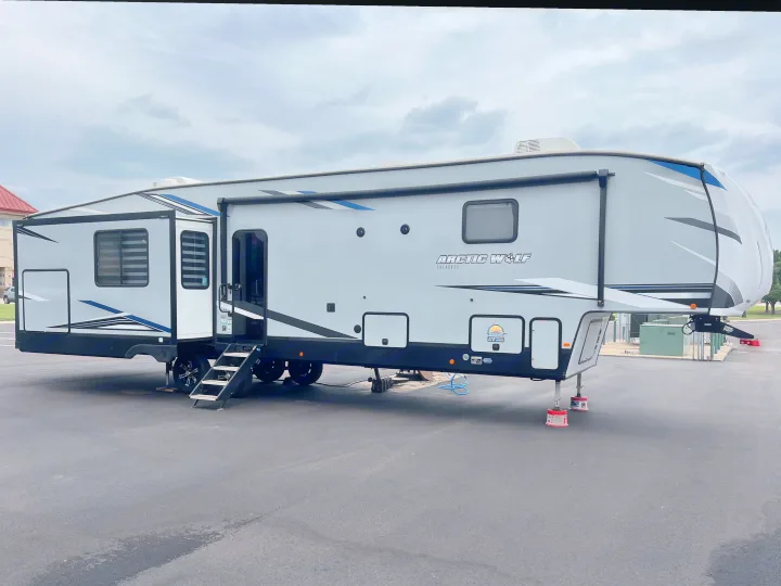 Modern Arctic Wolf fifth-wheel RV rental, parked with slide-outs extended and entry steps down.. Forest River Cherokee Arctic Wolf 2022