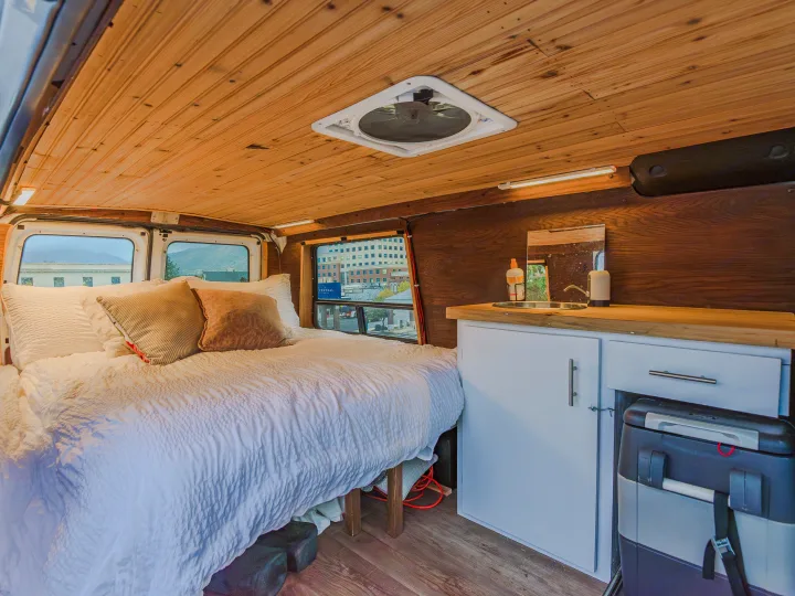 This cozy rv rental camper van interior has a comfy bed, mini kitchen with sink, wood-paneled ceiling & walls.. Ford Econoline E250supercab 2008