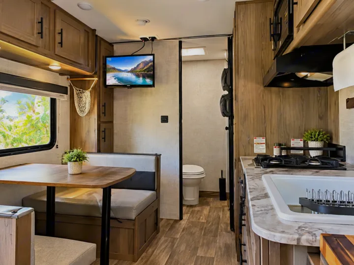 This rv rental features a compact, modern interior: dinette, kitchen with stove/sink, TV, and a private bathroom.. Gulf Stream Conquest 2022