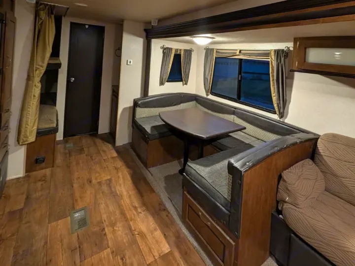 RV rental living space featuring a comfortable dinette with U-shaped seating, bunk beds, and wood-look flooring.. Forest River Salem 2017