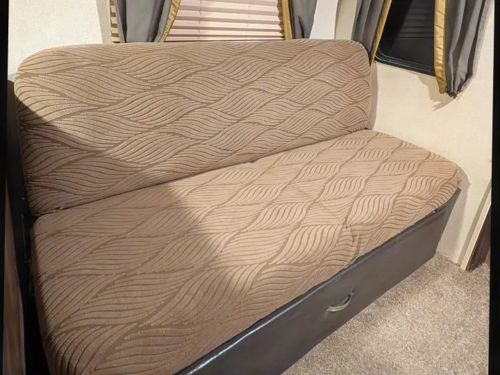 RV rental dinette seating featuring cozy, wavy-patterned cushions and a dark storage base, perfect for travel comfort.. Forest River Salem 2017