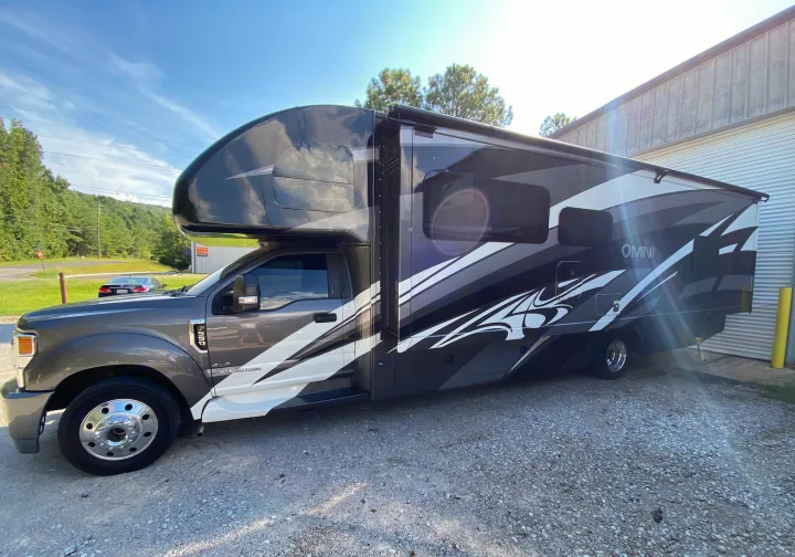 This sleek grey and black Omni RV rental, featuring bold graphics, is ready for your next adventure.. Thor Super C 2021