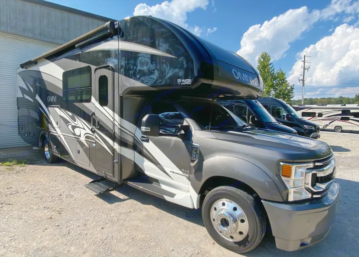 Gray and white Thor Omni motorhome, an excellent rv rental option, parked at an outdoor sales lot under a blue sky.. Thor Super C 2021