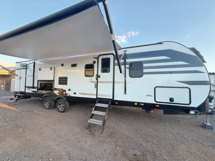 A modern white RV rental with a deployed awning, LED lighting, and outdoor kitchen, ready for your next adventure.. Heartland RVs Mallard 2021