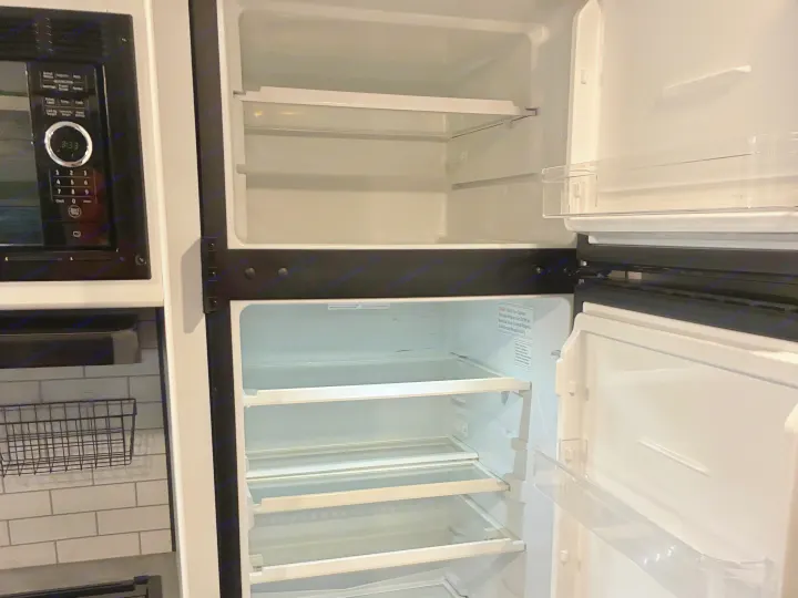 Empty, pristine refrigerator and microwave (3:33) in an rv rental kitchen, ready for your travel provisions.. Keystone RV Hideout 2022