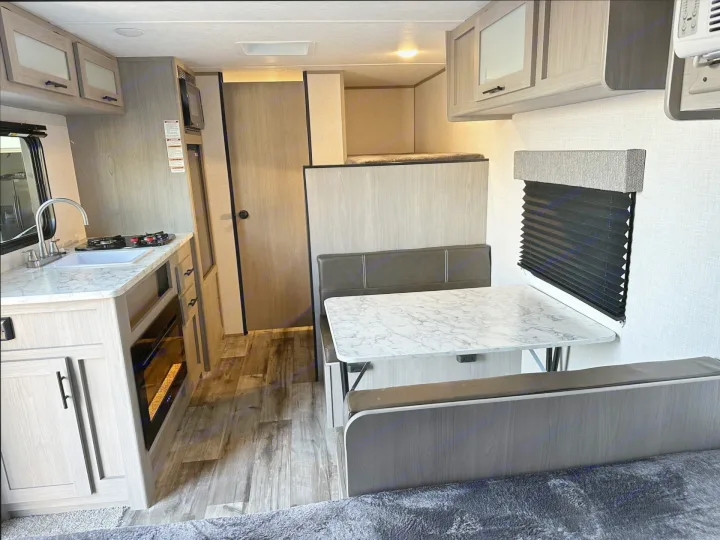 This modern RV rental features a compact interior with a kitchen, dinette, upper bunk bed, and fireplace, perfect for travel.. Coleman Lantern 17b 2023