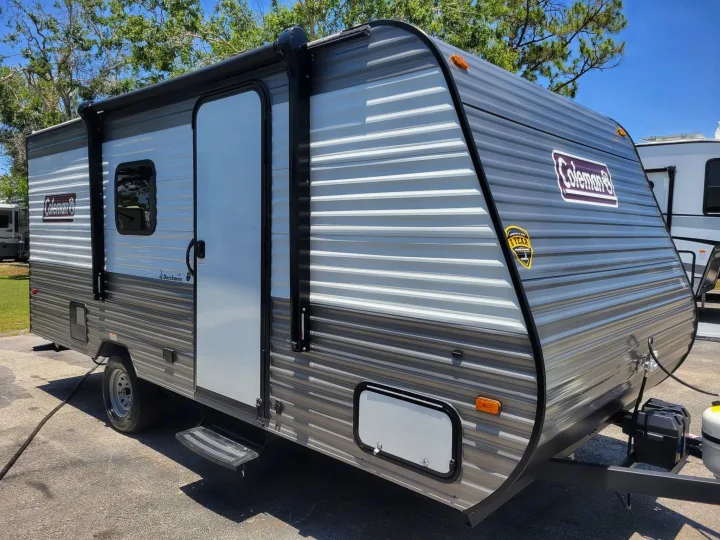 This gray & white striped Coleman travel trailer is perfect for your next RV rental. Ready for camping & outdoor adventures!. Coleman Lantern 17b 2023