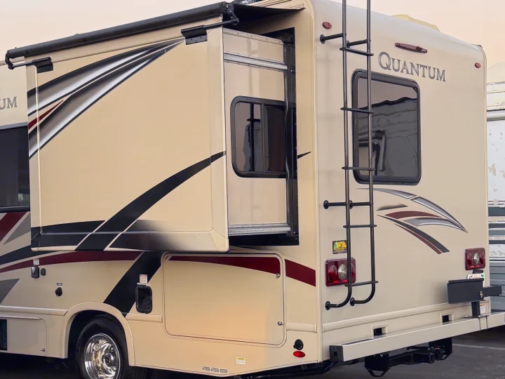 This beige Quantum RV rental, with its slide-out extended and rear ladder, is ready for your next motorhome adventure.. Thor Quantum 2018