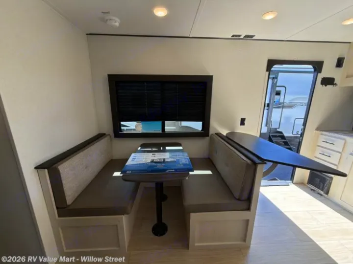 Inside your RV rental: a bright dinette area with built-in benches, a window, and a flexible table for dining or work.. Coachmen Shasta 2027