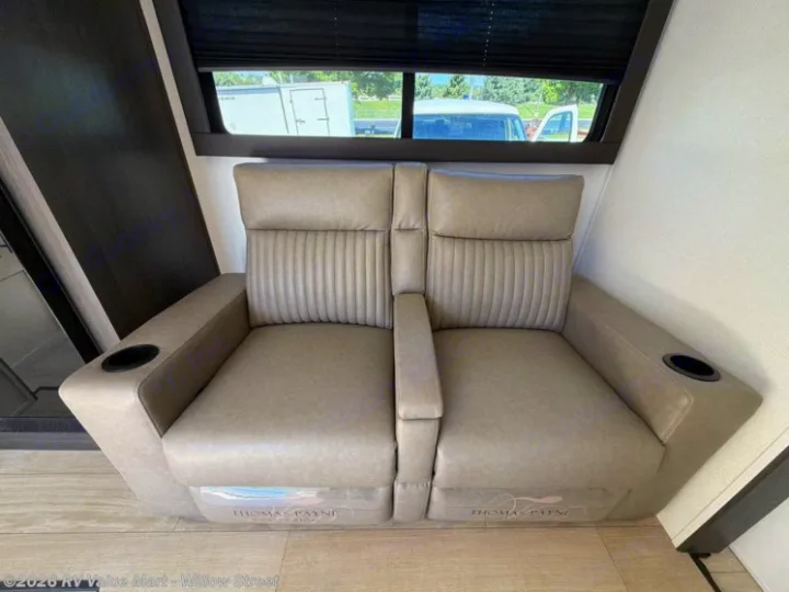 Light gray Thomas Payne RV recliners with cup holders in an RV rental interior, offering comfortable theater seating.. Coachmen Shasta 2027
