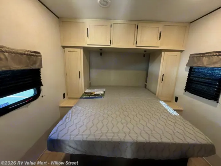 Bright RV rental bedroom with a comfy queen bed, overhead cabinets, and side storage, perfect for your next adventure.. Coachmen Shasta 2027