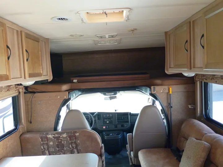 RV rental interior: View from the rear showcasing the driver's cabin, overhead bed, and main living space.. thor coachman 2015