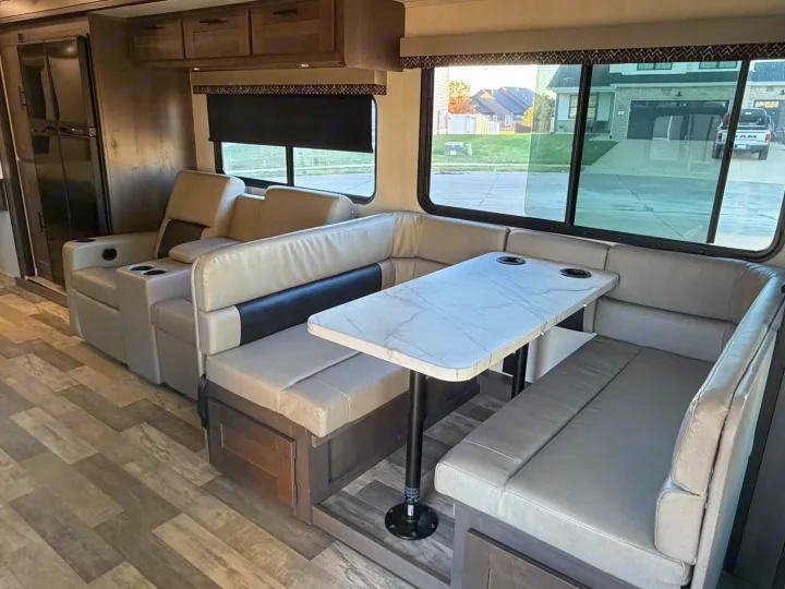 Spacious RV rental interior with a comfy U-shaped dinette, two recliners, and a full-size fridge. Ready for adventure!. FR3 FR3 Motorhome 2022