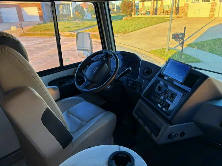RV rental cockpit: Driver's seat, dashboard with screen (8:49 AM), and steering wheel of a motorhome.. FR3 FR3 Motorhome 2022